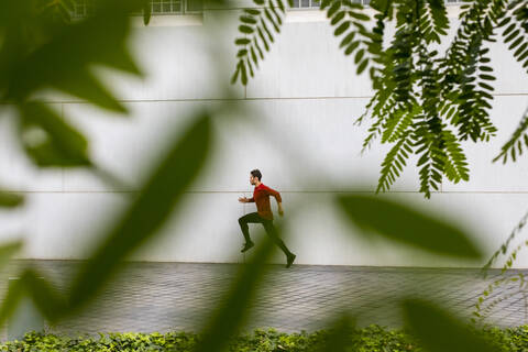 Junge Athletin beim intensiven Lauftraining in der Stadt, lizenzfreies Stockfoto