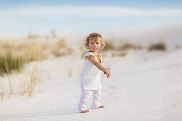 Caucasian boy walking on sand dune - BLEF14206