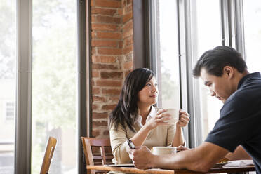 Chinese couple drinking coffee in cafe - BLEF14251