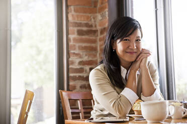 Chinese woman drinking coffee in cafe - BLEF14252