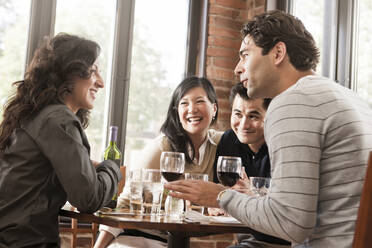 Friends drinking red wine together in restaurant - BLEF14253