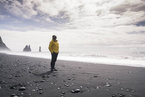 Mature man walking on a lava beach in Iceland - UUF18678