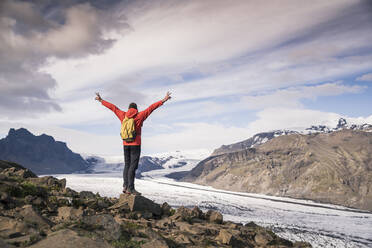 Älterer Mann steht im Skaftafell-Nationalpark und blickt auf den Vatnajokull-Gletscher, Island - UUF18693