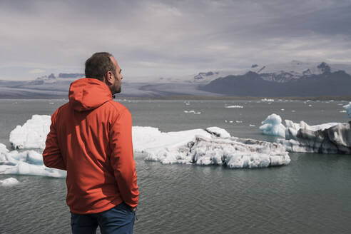 Mature man watching Vatnajokull glacier, Iceland - UUF18720