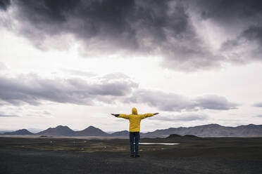 Mature man standing in Icelandic Highlands, with arms out - UUF18745