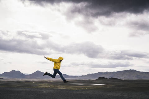 Älterer Mann, der vor Freude springt, in der Hochlandregion, Island, lizenzfreies Stockfoto