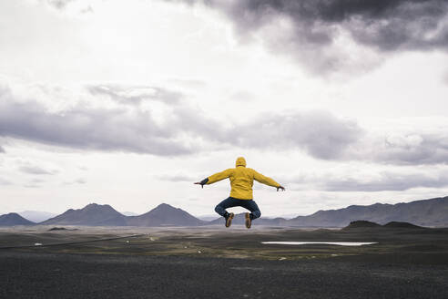 Mature man jumping for joy in the Highland Region, Iceland - UUF18748