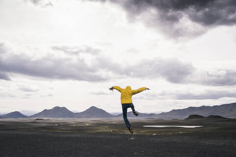 Älterer Mann, der vor Freude springt, in der Hochlandregion, Island, lizenzfreies Stockfoto