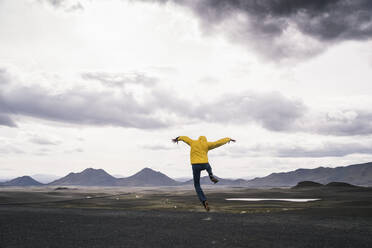 Mature man jumping for joy in the Highland Region, Iceland - UUF18749