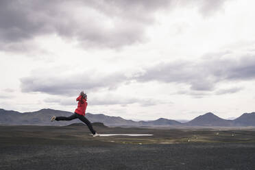 Mature man jumping for joy in the Highland Region, Iceland - UUF18750