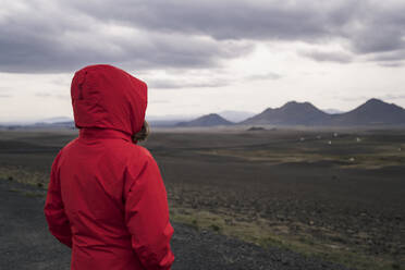 Young woman looking at highlands, Iceland - UUF18751
