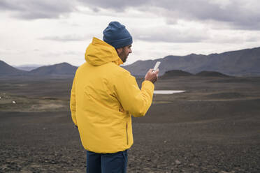 Älterer Mann mit Smartphone im isländischen Hochland - UUF18760