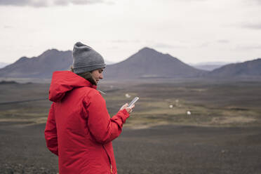 Young woman using smartphone in the Icelandic highlands - UUF18761