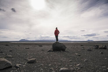 Reifer Mann, der auf einem Felsen im vulkanischen Hochland von Island steht - UUF18780