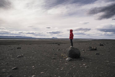 Young woman standing on a rock in the volcanic highlands of Iceland - UUF18781