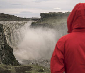 Junge Frau mit Blick auf die Dettifoss-Wasserfälle, Island - UUF18783