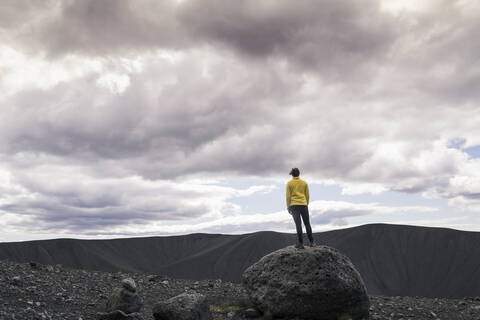 Young woman standing on Hverfjall crater near Myvatn, Iceland, taking pictures stock photo