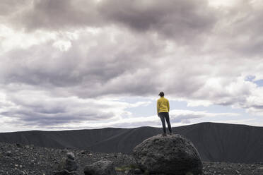 Young woman standing on Hverfjall crater near Myvatn, Iceland, taking pictures - UUF18787