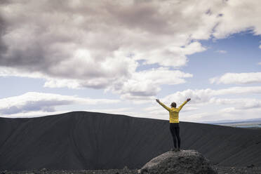 Young woman standing on Hverfjall crater near Myvatn, Iceland - UUF18788