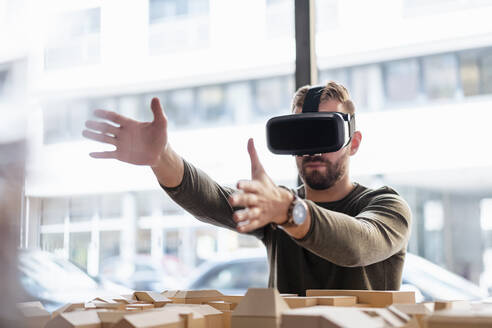 Mann mit Architekturmodell im Büro mit VR-Brille - DIGF07914