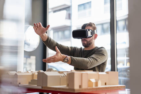 Mann mit Architekturmodell im Büro mit VR-Brille - DIGF07915