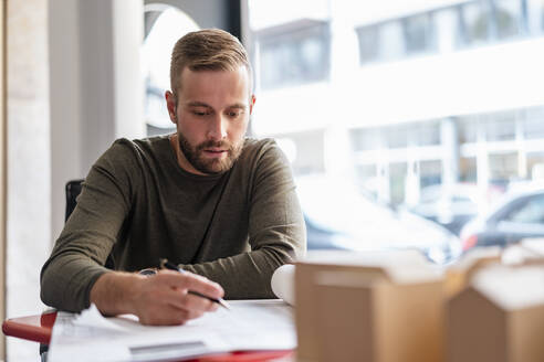 Architekt arbeitet an einem Plan im Büro - DIGF07916