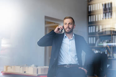 Geschäftsmann am Mobiltelefon im Büro - DIGF07931