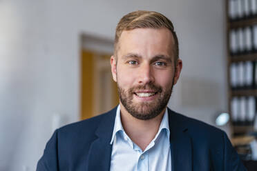 Portrait of smiling businessman in office - DIGF07932