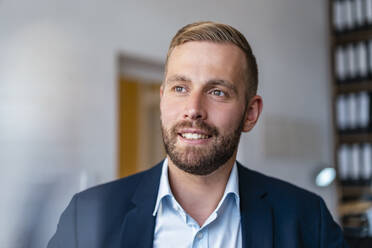 Portrait of smiling businessman in office - DIGF07934