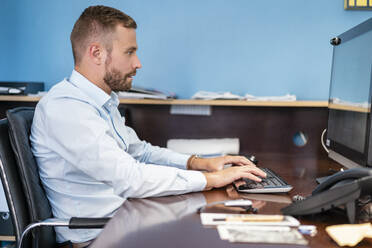 Geschäftsmann arbeitet an einem Desktop-PC im Büro - DIGF07951