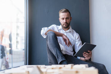 Geschäftsmann mit Tablet und Architekturmodell im Büro - DIGF07969