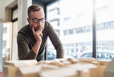 Mann betrachtet Architekturmodell im Büro - DIGF07979