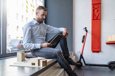 Geschäftsmann mit Tablet und Architekturmodell im Büro - DIGF07991