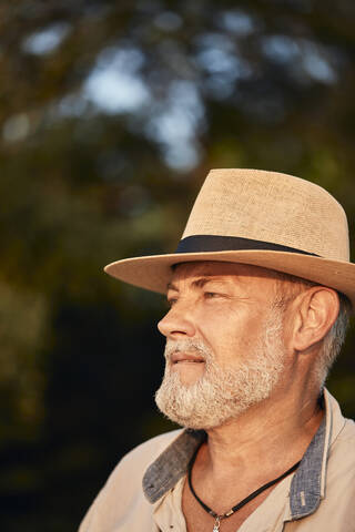 Porträt eines nachdenklichen älteren Mannes mit Sommerhut im Freien, lizenzfreies Stockfoto