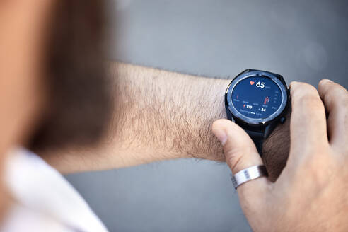 Close-up of man checking medical data on smartwatch - ZEDF02563