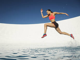 Caucasian woman running on water surface - BLEF14284