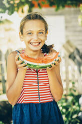 Caucasian girl eating watermelon outdoors - BLEF14316