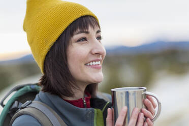 Hispanic woman drinking coffee outdoors - BLEF14329