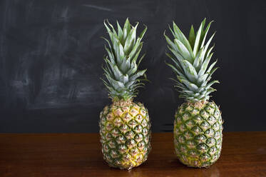 Zwei Ananas auf einem Holztisch, Studio - ASF06476