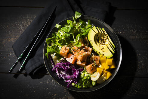 Directly above shot of poke bowl with chopsticks on wooden table - MAEF12908