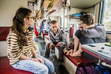 Kaukasische Freunde unterhalten sich im Zug auf einer Autoreise - BLEF14358