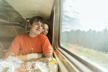 Kaukasisches Paar schaut aus dem Zugfenster - BLEF14359