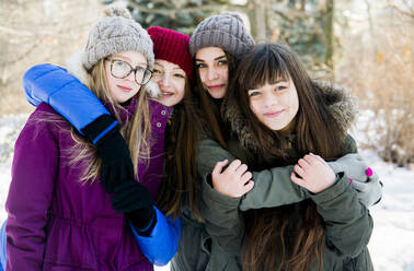 Kaukasische Mädchen umarmen sich im verschneiten Feld - BLEF14366