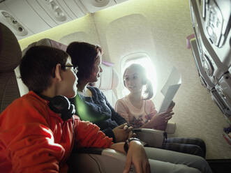 Mother and children talking in airplane - BLEF14386