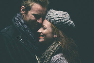 Smiling couple wearing warm clothing hugging - BLEF14412