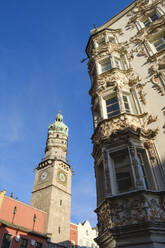 Tiefblick auf Stadtturm und Helbling-Haus vor blauem Himmel in Innsbruck, Österreich - SIEF08884