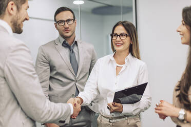 Caucasian business people shaking hands in office - BLEF14492