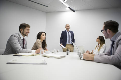 Kaukasische Geschäftsleute unterhalten sich in einer Bürobesprechung, lizenzfreies Stockfoto