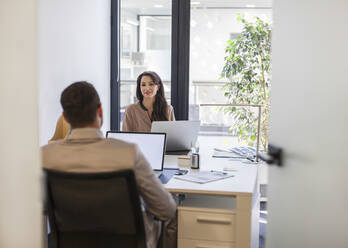 Kaukasische Geschäftsleute arbeiten an Schreibtischen im Büro - BLEF14515