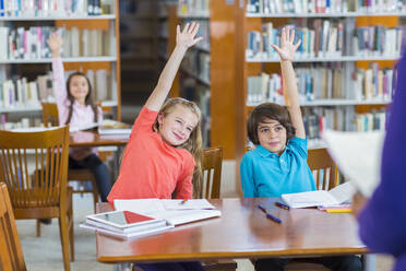 Studenten heben ihre Hände in der Bibliothek - BLEF14518
